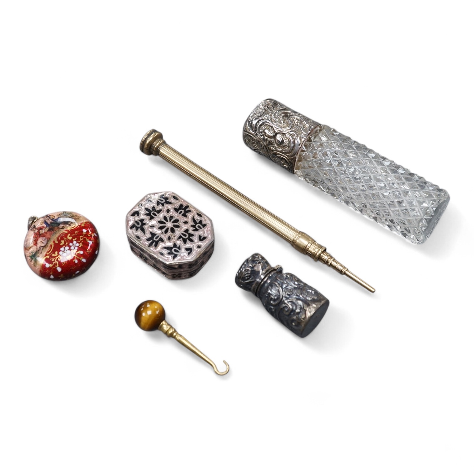 A 19th century Viennese gilt white metal and enamel circular vinaigrette, makers mark J.i.G, diameter 29mm, together with two late 19th century silver mounted senet bottles, a white metal and enamel pill box, a propellin
